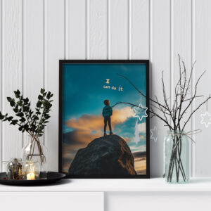 : Framed motivational art print featuring a young person standing on a rock with a vibrant sky in the background. The text "I can do it" is displayed in bold letters above the figure.