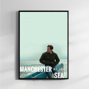 Framed poster of Manchester by the Sea featuring a man sitting thoughtfully by the sea in a minimalist design, displayed on a neutral-colored wall.