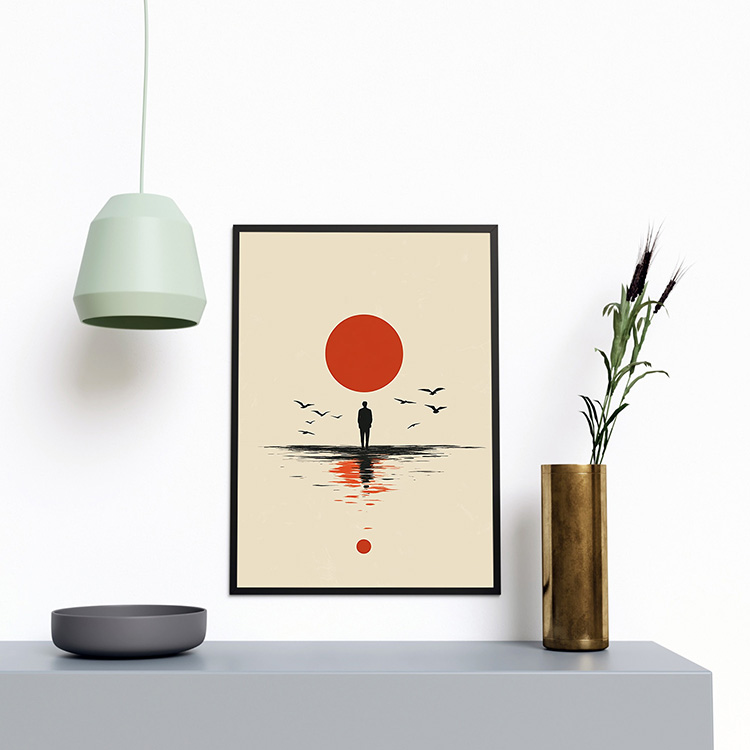 Framed minimalist poster of a lone figure standing by the water with a large red sun above, birds flying around, and reflections in the water, displayed on a wooden stool against a neutral wall.