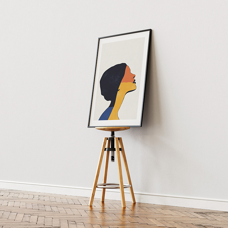 Framed abstract poster featuring a colorful silhouette profile in shades of orange, yellow, and blue, displayed on a wooden floor against a light wall.